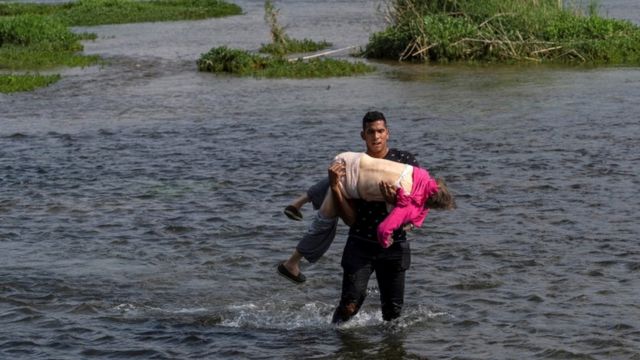 La historia detrás de la dramática foto de una anciana venezolana que cruzó en brazos de un joven el río Bravo desde México a EE.UU.